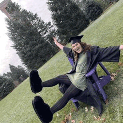 Abby Scheel in a graduation cap and gown amd TC's feet.