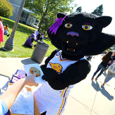 Shelby as TK being handed a cookie at a campus event