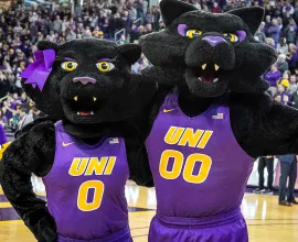 TC and TK on the McLeod Center basketball court in front of a full crowd.