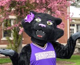 TK posing in front of blooming flowers.